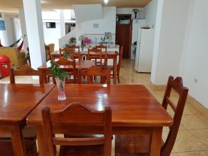 a dining room with a wooden table and chairs at Hostal Cerro Azul in Puerto Villamil