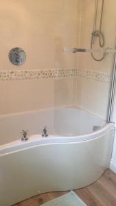 法利的住宿－Sandy bay 56 sunrise drive first floor apartment，浴室设有带淋浴的白色浴缸。