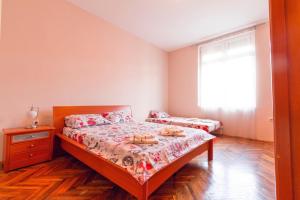 um quarto com uma cama, uma cómoda e uma janela em Apartment Sofija em Niš