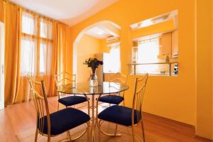 Un comedor con una mesa de cristal y sillas. en Apartment Sofija, en Niš