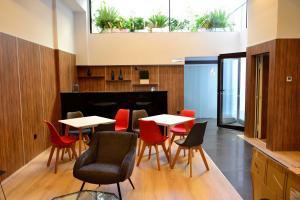 Un comedor con mesas y sillas y plantas. en Hotel Alda Estación Ourense, en Ourense