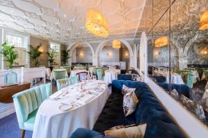 a restaurant with white tables and green chairs at The Metropole Hotel Cork in Cork