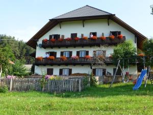 ein Haus mit einem Balkon mit Blumen darauf in der Unterkunft Schartnerhof in Klobenstein