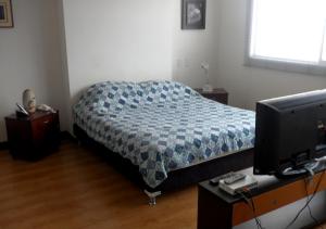 a bedroom with a bed and a desk with a computer at Apartamento Amoblado en el Poblado Medellín Colombia in Medellín