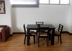 a black dining room table with chairs and a couch at Apartamento Amoblado en el Poblado Medellín Colombia in Medellín