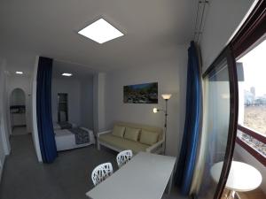 una sala de estar con un sofá y una cama en Apartamentos Juan Pérez- Viviendas Vacacionales, en Las Palmas de Gran Canaria