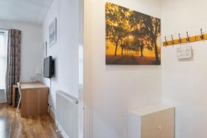 un pasillo con paredes blancas y una pintura en la pared en Fraser Apartment en Aberdeen