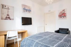 a bedroom with a bed and a desk and a tv at Fraser Apartment in Aberdeen
