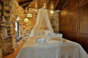 1 dormitorio con 1 cama blanca con dosel en Agkaze en Palaios Panteleimon