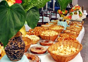 una mesa larga con cestas de pasteles. en Prive Thermas - OFICIAL, en Caldas Novas