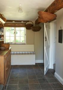 a kitchen with a bench and a window and a door at Park Farm in Daventry