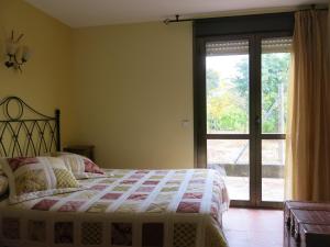 Schlafzimmer mit einem Bett und einer Glasschiebetür in der Unterkunft 75 Avenida de la Rioja in San Vicente de la Sonsierra