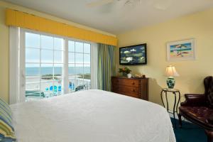 a bedroom with a bed and a view of the ocean at Winstead Beach Resort in Harwich Port