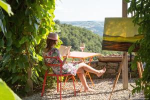 a woman sitting at a table with a glass of wine at Art et Création in Saint-Bérain