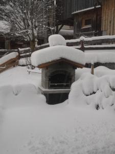 un patio cubierto de nieve junto a un banco en Ferienhaus Nadine, en Kappl