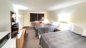 a hotel room with two beds and a flat screen tv at Travelers Inn in Belleville