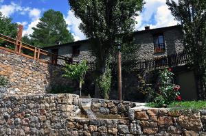 una pared de piedra frente a una casa en Apartamento Molí de Fòrnols en Fornols