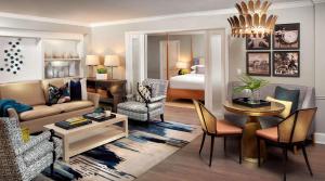 a living room with a couch and a room with a bed at La Playa Beach & Golf Resort, a Noble House Resort in Naples