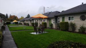 a yard with a table with an umbrella at Milwaukie Inn Portland South in Milwaukie