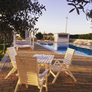 un grupo de sillas sentadas junto a una piscina en Masseria Gravelle, en Turi