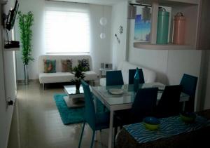 sala de estar con mesa y sillas azules en Apartamento con Piscina En el Rodadero Santa Marta Colombia, en Santa Marta