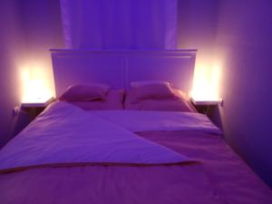 a bedroom with a bed with two lights on it at Borókahaus in Tata