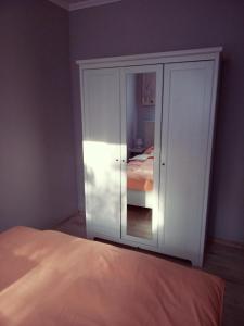 a white cabinet in a bedroom with a bed at Borókahaus in Tata