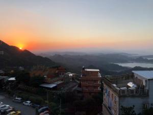 uma vista para o pôr-do-sol a partir de um edifício em Jiufen HappyLand B&B em Jiufen