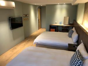 Uma cama ou camas num quarto em Jiufen HappyLand B&B
