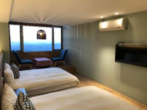 Uma cama ou camas num quarto em Jiufen HappyLand B&B