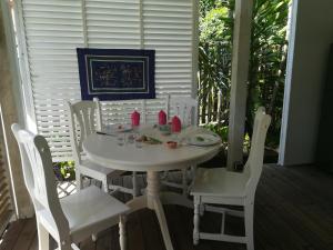 a white table and chairs on a porch at la case dentelle bungalow in Le Diamant