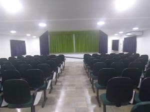 una habitación vacía con sillas y una pared verde en Pousada Cecosne, en Recife