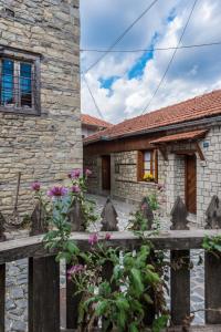une maison en pierre avec une clôture en bois devant elle dans l'établissement To Patriko Tou Saranti, à Metsovo