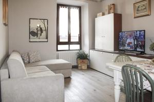 un soggiorno con divano e tavolo di Case Vacanze ai Burattini ad Adrara San Rocco