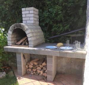 einen Steintisch mit zwei Tellern und einem Pizzaofen in der Unterkunft Tiny house with a big heart in Postojna