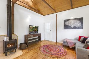 a living room with a fireplace and a couch at Blue Apple Lodge in Bilpin
