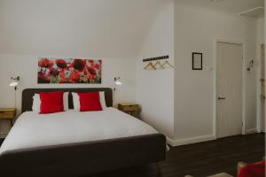 een slaapkamer met een groot bed met rode kussens bij The Loft @ Denver in East Maitland