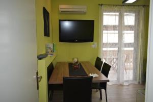 een eetkamer met een tafel en een televisie aan de muur bij APARTMENT ALEXANDRA in Nafplio