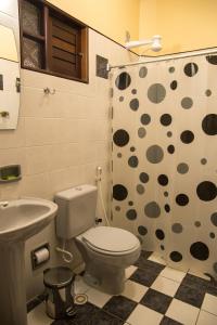 a bathroom with a toilet and a shower curtain at Hotel Pousada Arco Iris in Barra de Santo Antônio