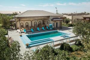 a swimming pool in front of a house at Hotel Asia Khiva in Khiva