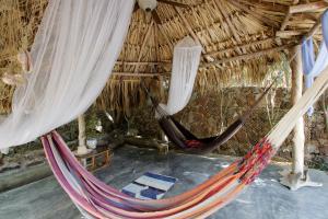 El Yaque的住宿－StevieWonderLand Playa El Yaque，一间位于稻草小屋内的客房,配有两张吊床