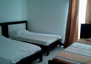 Habitación pequeña con 2 camas y ventana en Apartamento Familiar con Vista al Mar en San Andres, en San Andrés