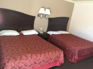 a hotel room with two beds and a red bedspread at Portal Motel in Lone Pine