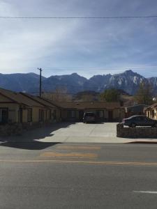 eine Straße mit einem Parkplatz mit Bergen im Hintergrund in der Unterkunft Portal Motel in Lone Pine