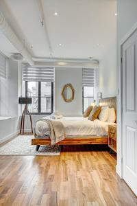 um quarto com uma cama grande e pisos em madeira em Saint Sulpice Lofts by Bakan - Old Montreal em Montreal