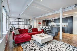 uma sala de estar com um sofá vermelho e uma mesa em Saint Sulpice Lofts by Bakan - Old Montreal em Montreal