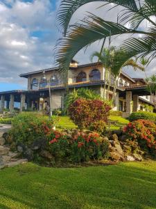 a building with palm trees and flowers in front of it at Hacienda Los Molinos Boutique Hotel & Villas in Boquete