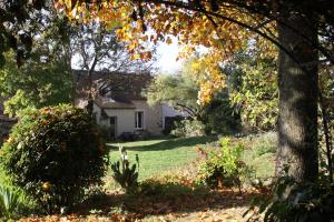 a house in the middle of a yard with trees at Chambres d'hôtes de la Fontaine in Beauchery