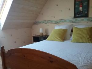 プルゲルノーにあるMénez ar Broc'hのベッドルーム1室(木製ベッド1台、黄色い枕付)