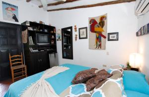 a bedroom with a blue bed and a tv at StevieWonderLand Playa El Yaque in El Yaque
